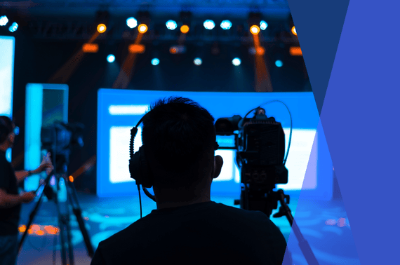 a man operating a camera for a live-streamed hybrid corporate meeting
